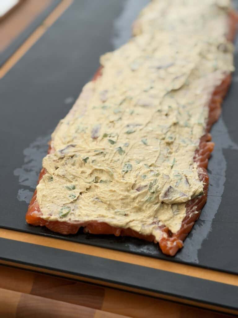 Cream Cheese on salmon on cutting board.