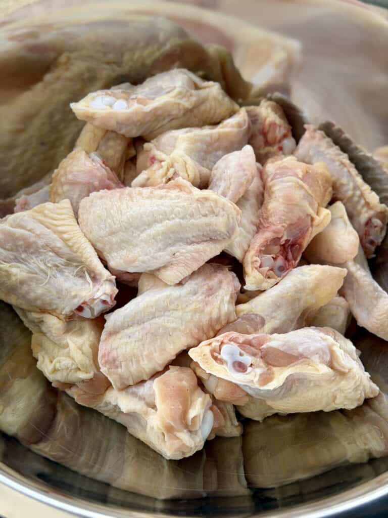 Uncooked Chicken wings cut and in bowl.