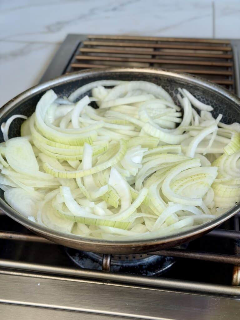 Onions sliced in pan.
