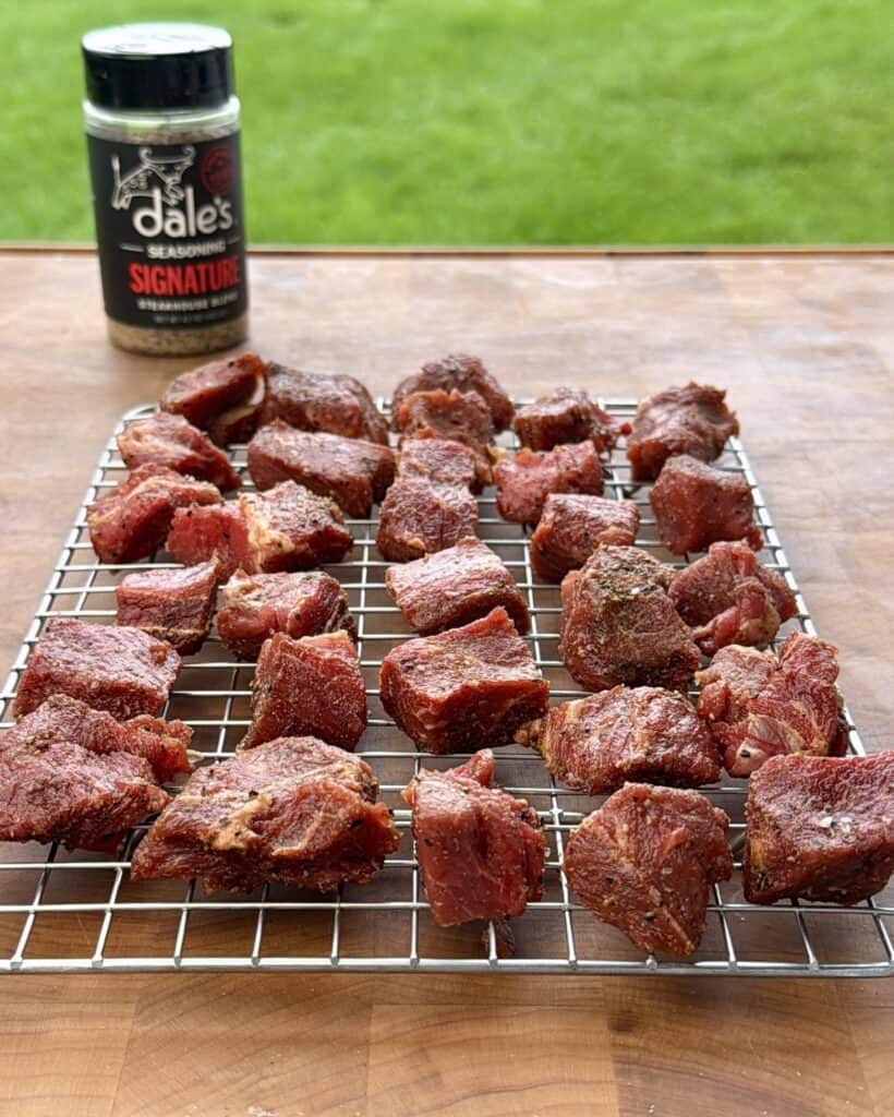 Seasoned stew meat on wire rack.