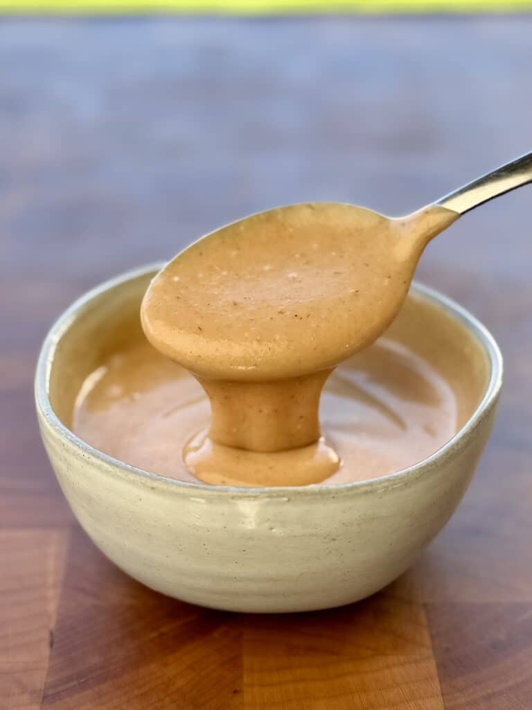 Creamy mixture in bowl with spoon.