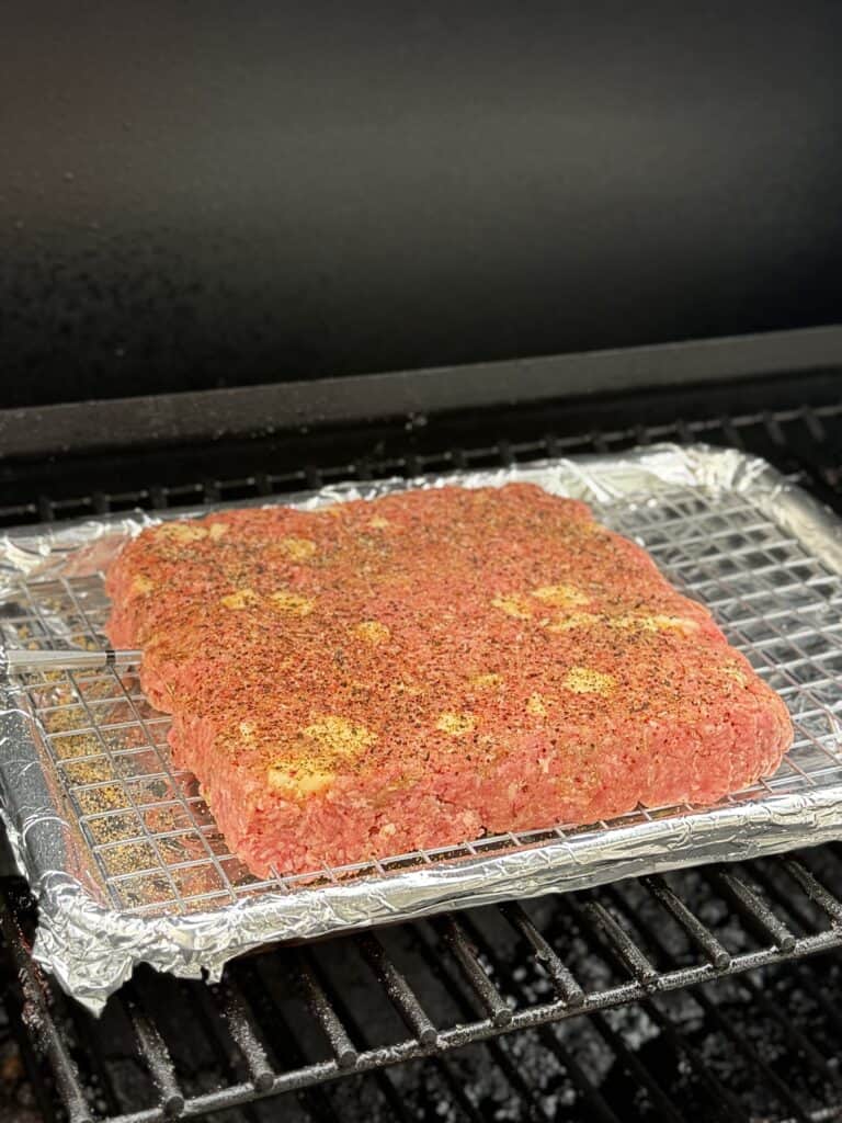 Smoked Cheeseburger Sliders smoking on the smoker.
