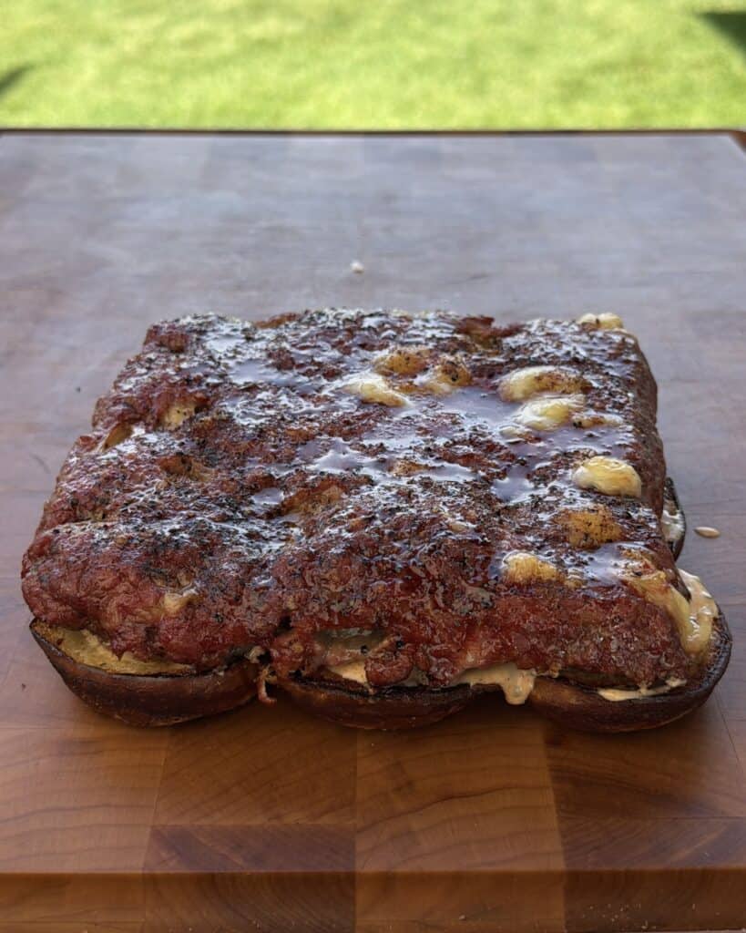 Burger on bun on cutting board.