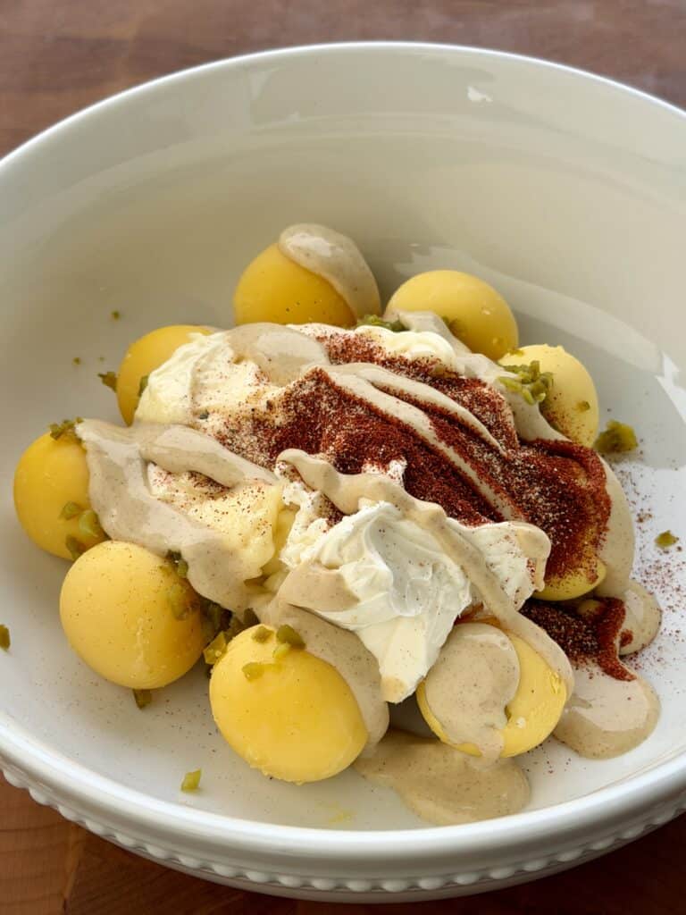 BBQ Deviled Eggs ingredients in bowl.