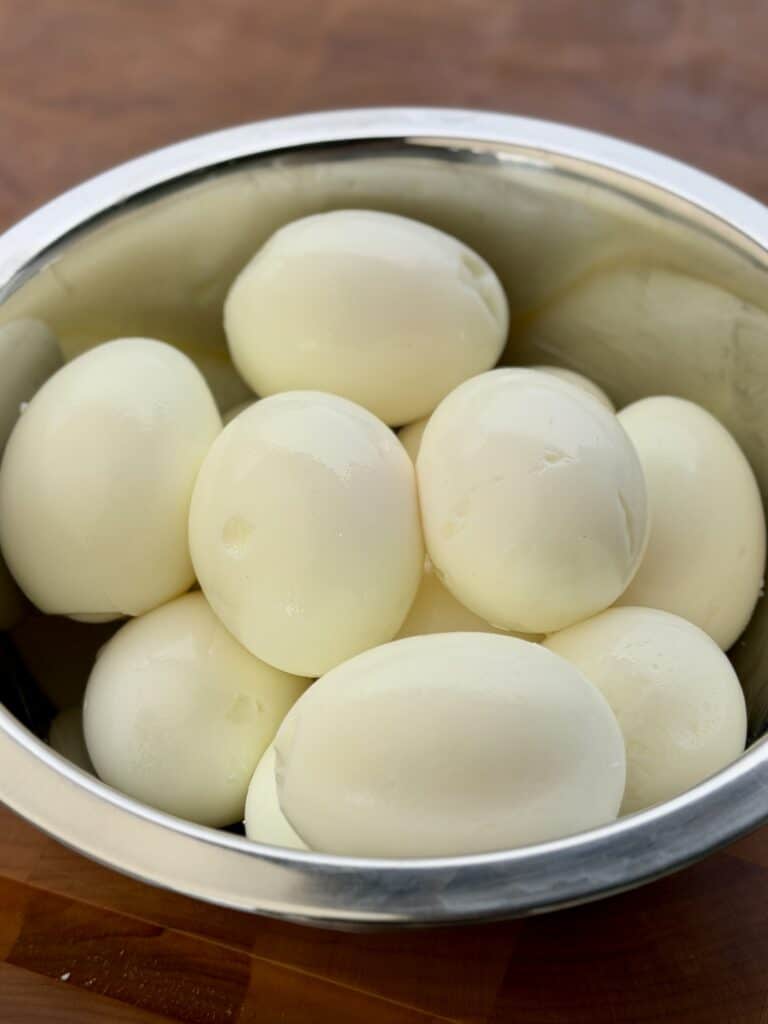 Peeled eggs in bowl.