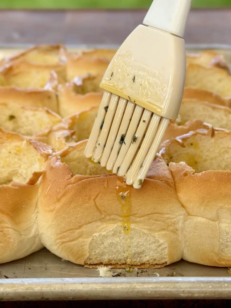 Brushing butter on buns.