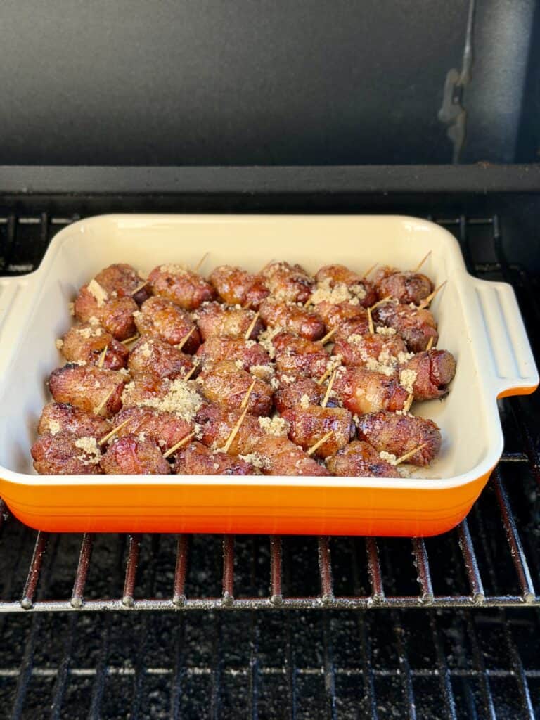 Smokies in baking dish on smoker.