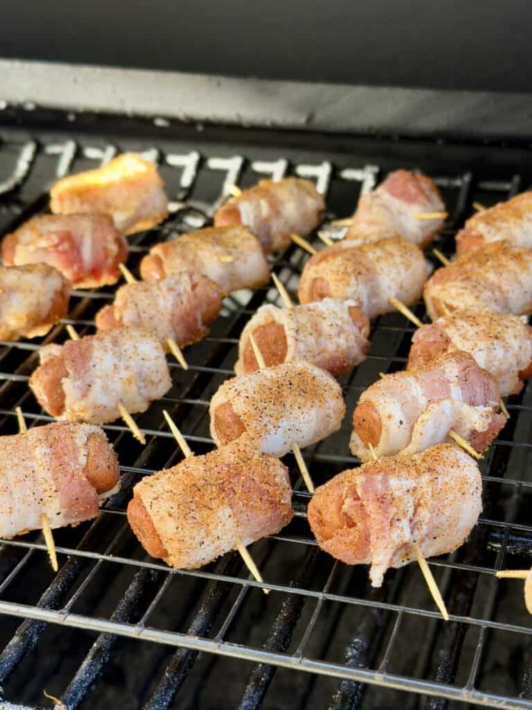Smokies wrapped in bacon on smoker.
