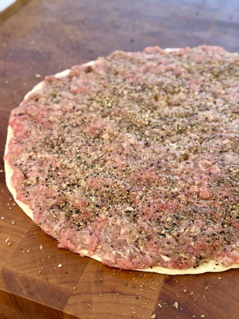 Seasoned hamburger on tortilla.