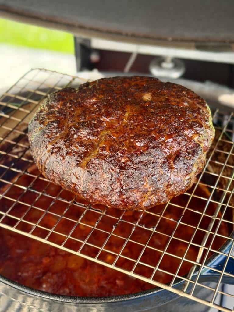 Burger on wire rack on smoker.