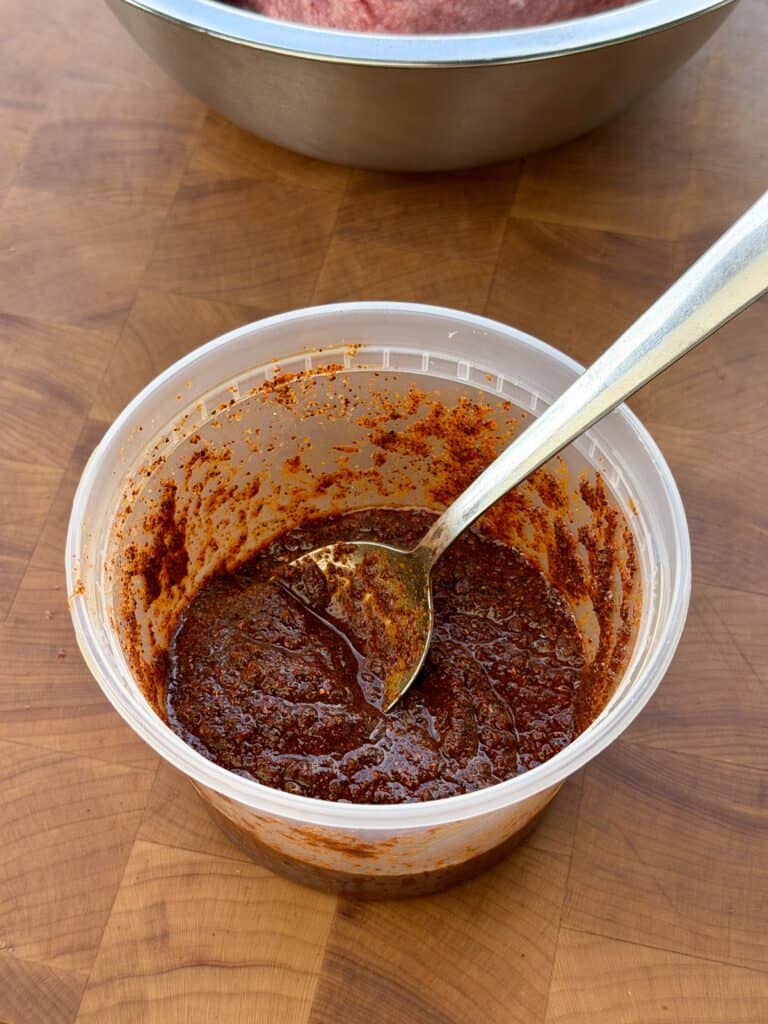 Sauce in plastic container with spoon.